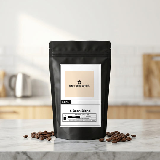 6 Bean Blend coffee bag standing on a marble kitchen counter, roasted beans scattered at its base
