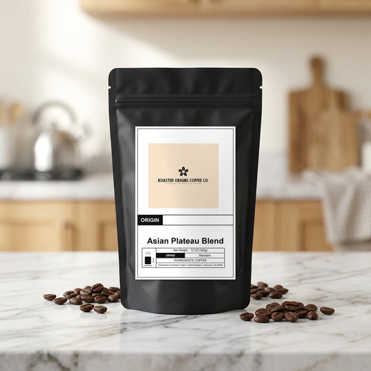 Asian Plateau Blend coffee bag standing on a marble kitchen counter, roasted beans scattered at its base