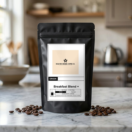 Breakfast Blend + coffee bag standing on a marble kitchen counter, roasted beans scattered at its base