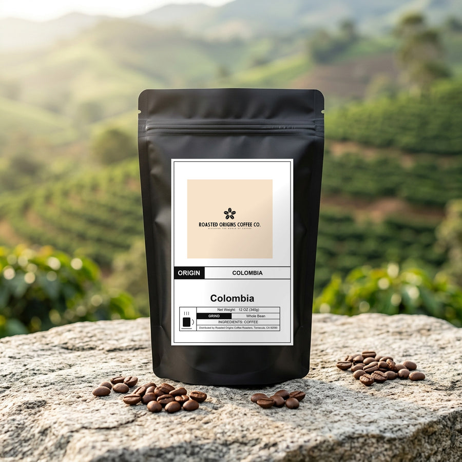 Colombia coffee bag standing on pale granite outdoors, roasted beans scattered at its base