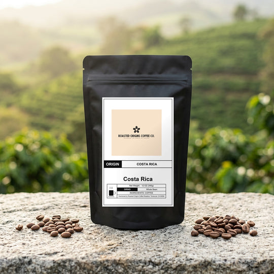 Costa Rica coffee bag standing on pale granite outdoors, roasted beans scattered at its base