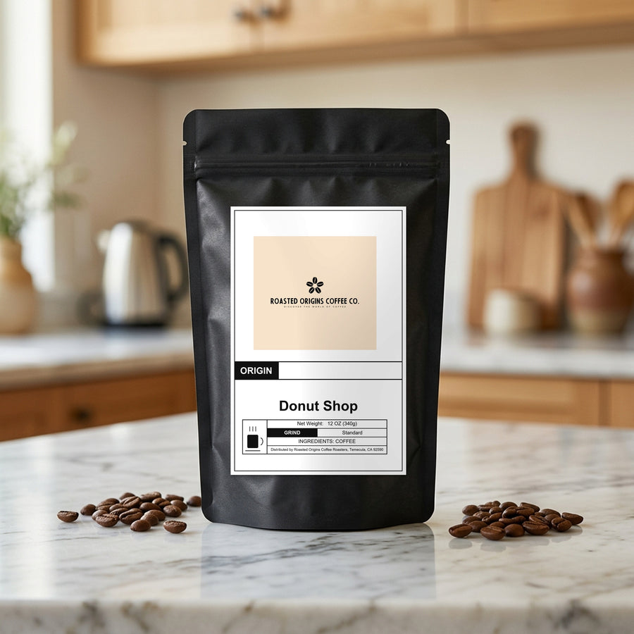Donut Shop coffee bag standing on a marble kitchen counter, roasted beans scattered at its base