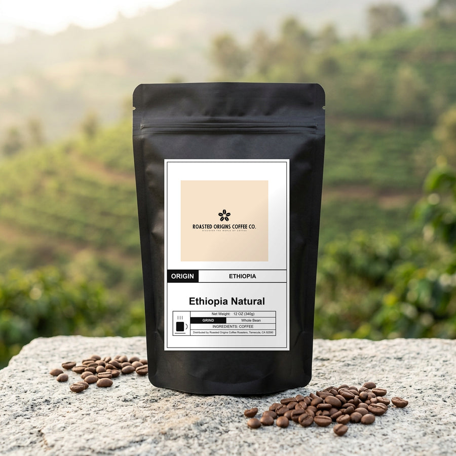 Ethiopia Natural coffee bag standing on pale granite outdoors, roasted beans scattered at its base